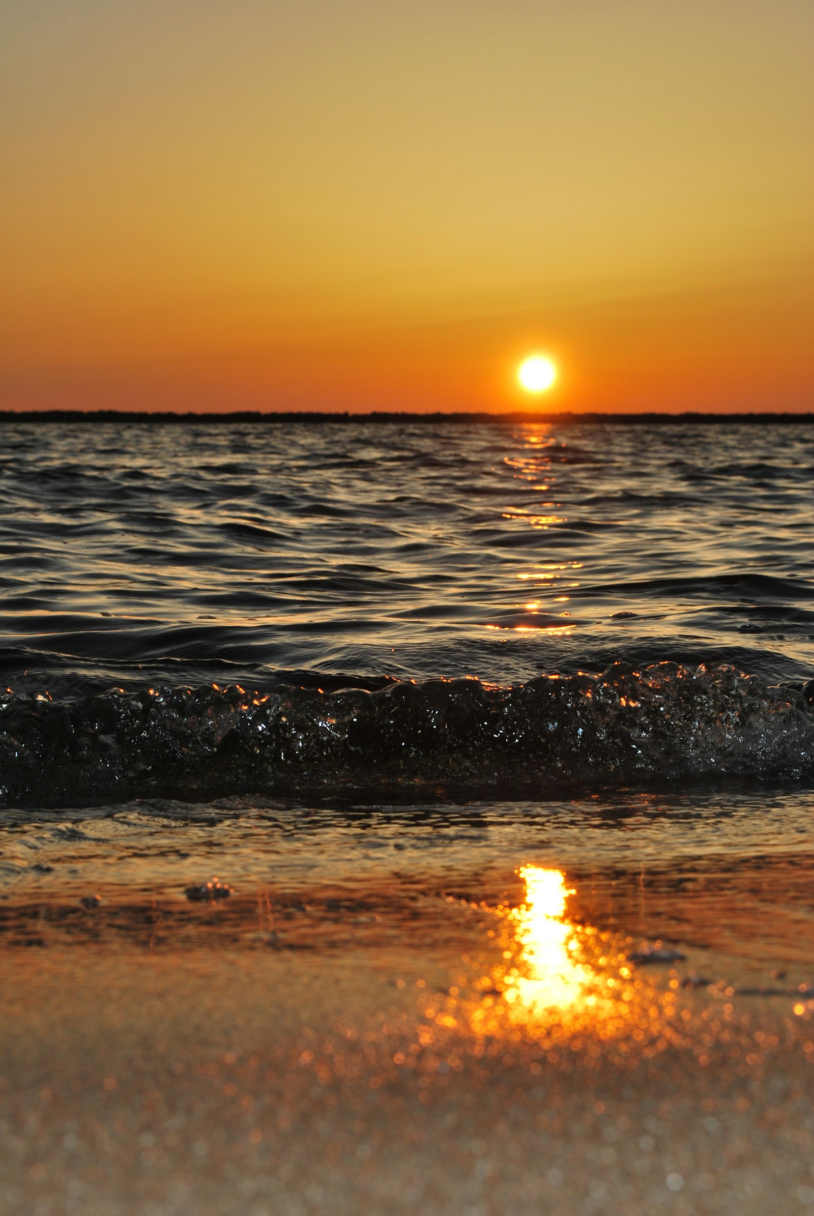The sun sitting low over the shoreline